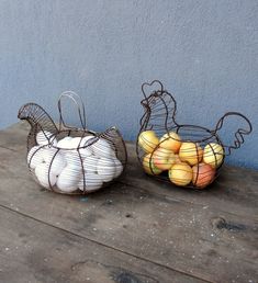 two wire baskets filled with fruit sitting on top of a wooden table