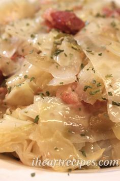 a white plate topped with cabbage and meat