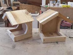 two wooden bird houses sitting on top of a table