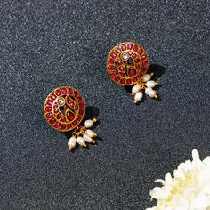 Introducing Neema Morni Studs by Yamoona—a blend of heritage and elegance. The red ruby stud features a red stone peacock tail, exuding grace and opulence. Delicate pearl hangings add femininity. Meticulous craftsmanship preserves tradition with a modern touch. The design symbolizes the regal peacock, deeply rooted in Indian culture. The combination of the red stones and pearls creates a timeless, elegant look. These studs effortlessly elevate your style for any occasion, leaving a lasting impre Luxury Ruby Earrings With Latkans, Ruby Earrings Indian, Red Stone Earrings, Gold Tops, Antique Gold Earrings, Gold Jewels Design, Peacock Tail, Stud Design, Gold Necklace Indian