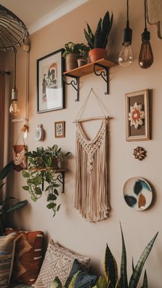 there are many plants and pictures on the wall in this room, including one hanging from a shelf