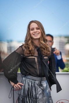 a beautiful young woman posing for the camera with her hands on her hips, wearing a black