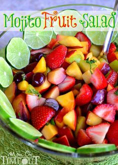 fresh fruit salad with limes and strawberries in a glass bowl