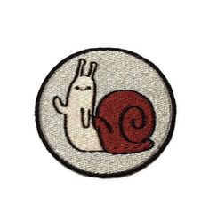 a white and red patch with a snail on it's back, in the shape of a circle