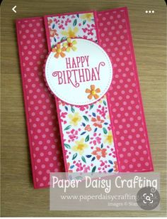 a birthday card with flowers and polka dots on pink paper, sitting on a table