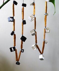 several pieces of wood are hanging from a branch with metal objects attached to it,