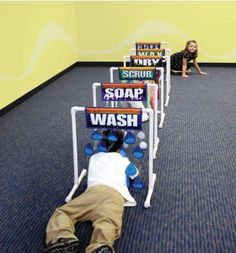 a child laying on the floor in front of a row of signs