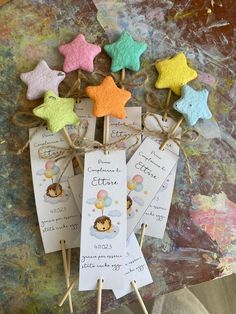 some little star shaped cookies are on top of small stick holders with tags attached to them