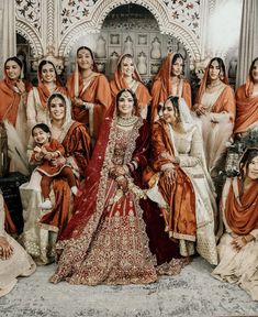 a group of women in orange and white outfits posing for a photo with each other