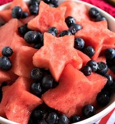 a bowl filled with watermelon and blueberries on top of an american flag table cloth