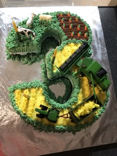 two cakes made to look like the number five with farm animals and tractors on them