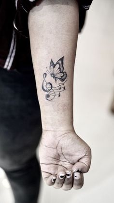 a woman's arm with a butterfly tattoo on the left side of her wrist