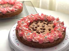 two cakes with pink frosting and sprinkles are on a white plate