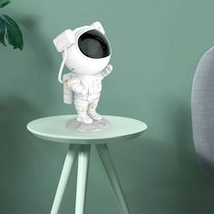 an astronaut figurine sitting on top of a small table