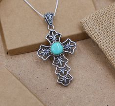 This stunning 11.5 gram silver cross pendant is a bold statement piece featuring a beautifully placed round turquoise stone at its center. The intricate design of the cross adds a touch of elegance and reverence, making it an exceptional choice for anyone who values both style and symbolic significance. Material: 925 Sterling Silver Weight: 11.5 grams Dimensions: 5 cm x 3 cm Center Stone: Turquoise Chain Length: 18 inches Design: Detailed cross design with a central turquoise stone that highligh Elegant Turquoise Cross Jewelry, Spiritual Cross Turquoise Necklace For Gift, Spiritual Turquoise Cross Necklace As Gift, Spiritual Turquoise Cross Necklace, Spiritual Turquoise Cross Necklace For Gift, Handmade Southwestern Cross Necklace, Southwestern Handmade Cross Necklace, Handmade Turquoise Cross Jewelry, Silver Turquoise Cross Necklace For Gift