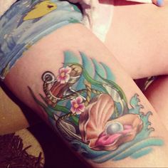 a woman's thigh with tattoos on her legs and an ocean themed tattoo design