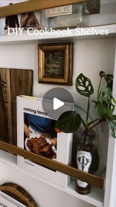 there is a shelf with some books on it and a potted plant in the corner