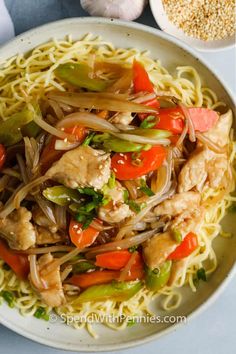 a white plate topped with noodles and chicken