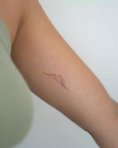 a woman's arm with a small tattoo on the left side of her arm