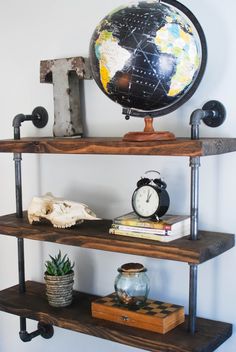 a bookshelf with two shelves and a globe on top