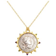 This DUBINI coin necklace from the 'Empires' collection features an authentic Macedon coin from 168-148 B.C. set in 18K yellow gold with bullet amethyst, garnet, topaz, citrine and peridot cabochons. Depicted on the coin: Macedonian shield with bust of Artemis at the center facing right, bow and quiver at her shoulder, on the obverse and MAKE∆ONΩN / ΠPΩTHΣ above and below club, all within oak wreath, on the reverse. Coin dimensions: circa 30mm The coin Medallion is provided with a long (75cm) Ro Bow And Quiver, Oak Wreath, Gold Medallion, Coin Pendant Necklace, Medallion Necklace, Antique Necklace, Modern Necklaces, Coin Jewelry, Silver Coin