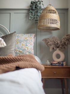 a bedroom with a bed, nightstand and hanging basket on the wall above it's headboard