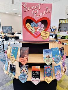 there are many books on display in the library and one has a heart shaped sign that says sweet reads