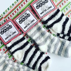 three pairs of black and white striped socks on top of a green and red patterned table cloth