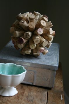 a white bowl sitting on top of a wooden table next to a pile of wine corks