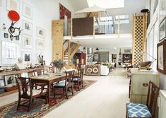 a dining room and living room are separated by an open floor plan with high ceilings