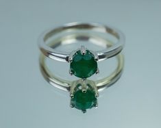 This is a beautiful Brazilian Emerald set in Sterling Silver. This amazing stone has the perfect deep green color that many look for in Emeralds accented beautifully by a 6 prong setting! This stone has visible inclusions and opaque clarity which is very common with Emeralds but also has a nice luster, you will not be disappointed!  Emeralds are the birthstone for May!  This perfect sized 6mm round cut Emerald weighs 0.740 and will go great with most styles or occasions. The size of these perfec Classic Green Gemstone With Center Stone, Round Cut Emerald Gemstones With Prong Setting, Emerald Ring With Vs Clarity And Round Cut, Classic Emerald Ring With Vs Clarity, Classic Round Emerald Ring With Vs Clarity, Round Cut Emerald Ring With Vs Clarity, Classic Round May Birthstone Gemstones, Green Emerald Ring With Prong Setting, Round Cut Green Emerald Gemstones