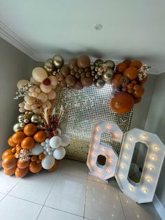 balloons and lights are arranged on the floor in front of a large number six sign