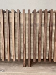 a wooden radiator on the floor in front of a wall with wood slats