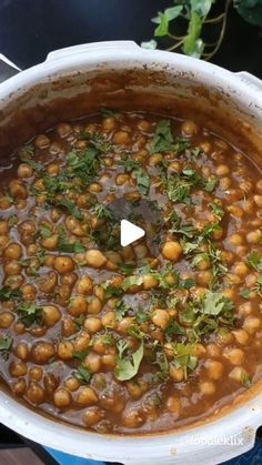 a pot filled with beans and herbs on top of a stove