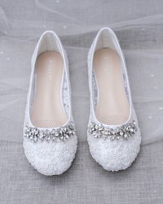 the brides wedding shoes are adorned with crystal stones and pearls, along with beading