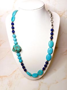 This necklace was created with natural stones of Lapis Lazuli, turquoise stone and turquoise paste beads. The balls are made of steel as is the clasp, Blue Beaded Necklaces With Stones For Jewelry Making, Adjustable Blue Howlite Necklaces, Turquoise Necklaces With Round Natural Stones, Artisan Blue Turquoise Stones Necklace, Blue Beaded Howlite Necklaces, Elegant Turquoise Beads With Natural Stones, Blue Howlite Round Bead Jewelry, Blue Turquoise Howlite Necklace With Round Beads, Blue Oval Beaded Necklaces With Natural Stones