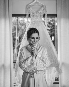 a woman standing in front of a wedding dress