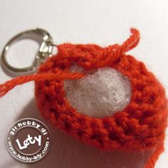 an orange crochet keychain with a button on it