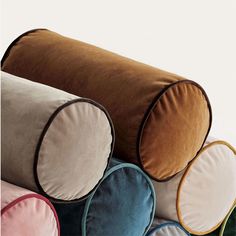 a group of round pillows stacked on top of each other in different colors and sizes