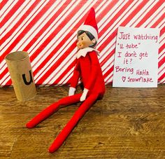 an elf is sitting on the floor next to a paper roll and a sign that says just watching u - tube i don't got it