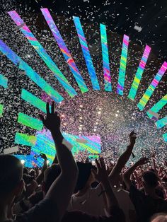 a large group of people at a concert with confetti in the air