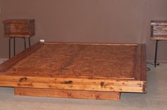 a bed frame made out of wood with two nightstands on either side and one end