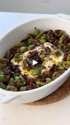 a white casserole dish filled with green beans and cheese on top of crackers