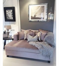 a living room filled with lots of furniture next to a wall mounted clock and framed pictures