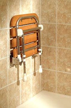 a wooden chair hanging from the side of a bathtub in a bathroom with tiled walls