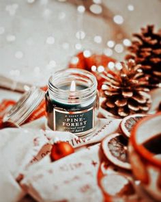 a candle sitting on top of a table next to some christmas decorations and other items