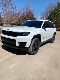 a white jeep is parked in the driveway