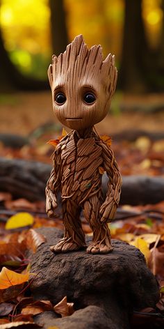 a baby groote figurine sitting on top of a pile of leaves