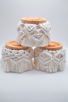 four white macrame bracelets with wooden beads and tassels on top