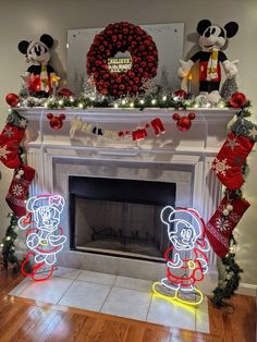 a fireplace decorated for christmas with mickey and minnie mouse decorations